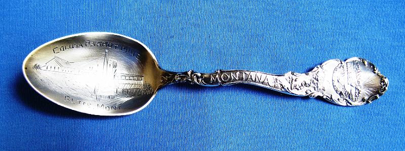 Souvenir Mining Spoon Colusa Parrot Mine.JPG - SOUVENIR MINING SPOON COLUSA PARROT MINE - Sterling silver spoon, 5 1/2 in.long, embossed mining scene in light gilt bowl with engraved COLUSA PARROT MINE BUTTE, MONT in bowl, weight 25 gms., ca. 1900, back with sterling and S hallmark markings, made by the Shepard Mfg. Co., back side shows lady holdingcrest and front side handle has MONTANA and miner with pick, top marked Oro y Plata (silver and gold)  [The Colusa-Parrot mine was the most productive of the mining properties owned by William A. Clark, the first of Butte’s Copper Kings.  In 1872, William A. Clark, a banker from the nearby town of Deer Lodge, visited the Butte district and examined some claims on the large black quartz reefs located just below the big butte overlooking the camp. Clark purchased four properties within the quartz-rich zone: the Original, the Colusa, the Mountain Chief, and the Gambetta claims. These four claims, together with his Travona silver mine, would launch Clark's career.  On Nov. 26, 1897 Clark organized the Colusa-Parrot Mining & Smelting Co.  With a main office at 10 W. Broadway St. in Butte, the company was a close corporation.  It was thought that Clark controlled all the stock in the company and none was ever traded on the open market.  The company operated the Original, Stewart and Colusa-Parrot mines along with a smelter.  The Colusa-Parrot mine had a two-compartment shaft 1400 feet deep with underground connections to the Parrot and Never Sweat mines operated by the Anaconda Copper Mining Co.  The mineral surface area of the Colusa-Parrot mine was a small 150 by 298 feet.  The mine produced low grade ore with large veins and employed 500-600 men at full employment.  Annual production in 1902 was 10-15 million pounds of refined copper.  The Colusa-Parrot mine became the source of a simmering litigation between Clark and Anaconda.  In May 1910, Clark sold his major copper properties including the Butte Reduction Works, Original Consolidated mine, the Montana Realty Co. and the Colusa-Parrot mine to the Anaconda Copper Mining Co. for $5M thus ending a long and tumultuous relationship with Anaconda. Clark served as a senator from Montana for a number of years and died in March 1925.]   